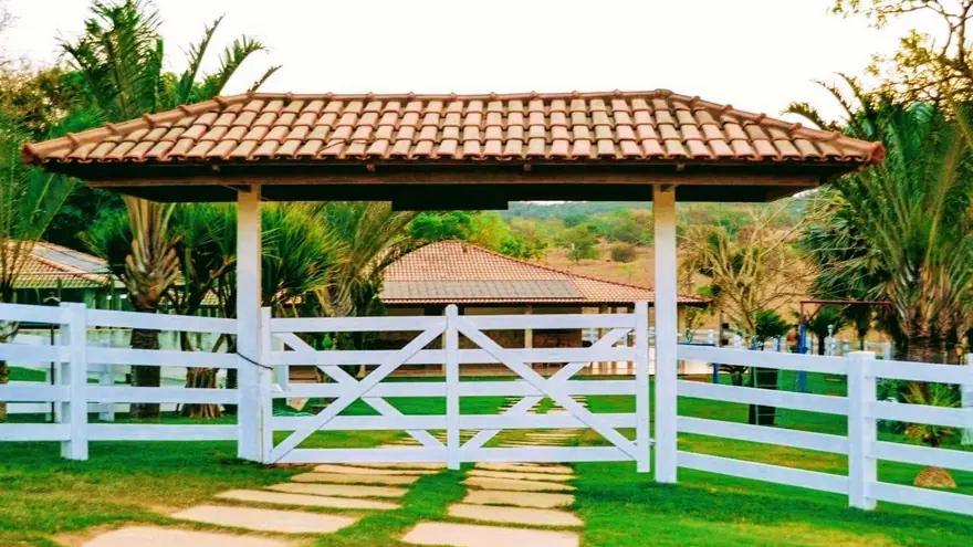 Quiosque e gramado cercados por cerca branca na clínica de reabilitação